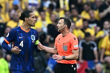 German referee Felix Zwayer speaks with Netherlands' defender Virgil van Dijk during the UEFA Euro 2024 round of 16 match against Romania.
