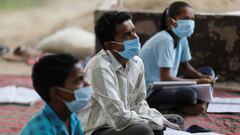 FILE PHOTO: Students of 9th class from a slum area, who do not have access to internet facilities and miss their online lessons, attend an open-air class taken by Satyendra Pal, a college student, after authorities closed all schools in March following th