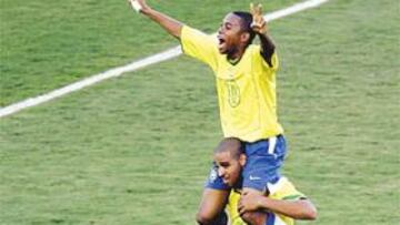 <b>VICTORIA. </b>Adriano levanta a Robinho tras uno de los goles conseguidos frente a Chile.