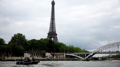 La policía francesa surcando las aguas del Sena en lancha, con la Torre Eiffel al fondo.