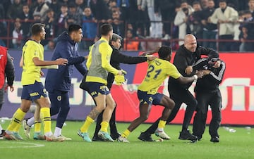 A Trabzonspor fan (R) attacks Fenerbahce players after the Super League match between Trabzonspor and Fenerbahce in Trabzon