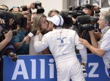 Williams' Brazilian driver Felipe Massa (C) is kissed by his wife Raffaaela Bassi (L) as he celebrates finishing third in the qualifying session of the Austrian Formula One Grand Prix at the Red Bull Ring in Spielberg, Austria on June 21, 2014.  AFP PHOTO CHRISTOF STACHE