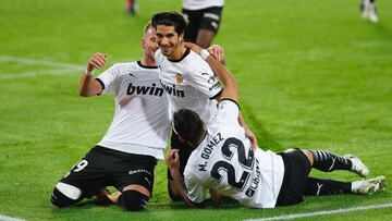 Maxi y Racic felicitan a Carlos Soler, tras uno de los goles marcados al Real Madrid.