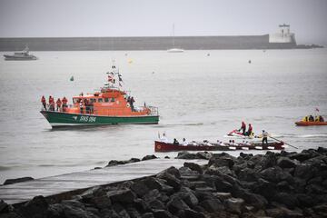 Un barco de rescate escolta la llama olímpica transportada a bordo de una trainera durante el relevo de la antorcha en el puerto de San Juan de Luz, suroeste de Francia.