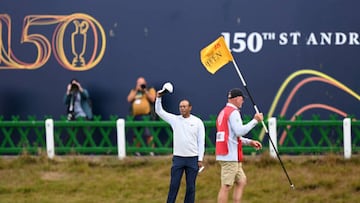 ST ANDREWS, SCOTLAND - JULY 15: Tiger Woods of the United States acknowledges the crowd as he crosses the Swilcan Bridge during Day Two of The 150th Open at St Andrews Old Course on July 15, 2022 in St Andrews, Scotland. (Photo by Ross Kinnaird/Getty Images)