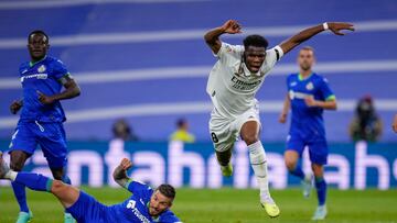 Real Madrid's Aurelien Tchouameni, center, goes for the ball next to Getafe's Portu during a Spanish La Liga soccer match between Real Madrid and Getafe at the Santiago Bernabeu stadium in Madrid, Spain, Saturday, May 13, 2023. (AP Photo/Manu Fernandez)