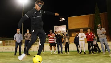 Luis Milla golpea el bal&oacute;n con un antifaz.