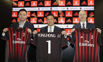 David Han Li, Yonghong Li, y Marco Fassone, los nuevos propietarios del AC Milan, posan con la camiseta del equipo italiano