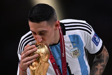 Ángel Di María kisses the FIFA World Cup Trophy in 2022.