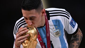 Argentina's midfielder #11 Angel Di Maria kisses the FIFA World Cup Trophy during the trophy ceremony after Argentina won the Qatar 2022 World Cup final football match between Argentina and France at Lusail Stadium in Lusail, north of Doha on December 18, 2022. (Photo by Kirill KUDRYAVTSEV / AFP)