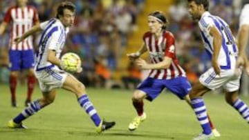 El defensa brasileño del At. de Madrid, Luis Filipe, intenta llevarse el balón ante los jugadores de la Real Sociedad, Xabi Prietoy Rubén Pardo.