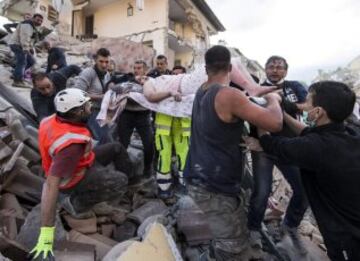 ITA16 AMATRICE (ITALIA) 24/08/2016.- Una mujer herida es rescatada de entre los escombros de un edificio en Amatrice, en el centro de Italia, hoy, 24 de agosto de 2016. Al menos 19 personas han fallecido y hay decenas de heridos tras el terremoto de 6 grados en la escala Richter que ha sacudido el centro de Italia esta madrugada, según informó la televisión pública RAI. EFE/Massimo Percossi