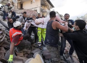 ITA16 AMATRICE (ITALIA) 24/08/2016.- Una mujer herida es rescatada de entre los escombros de un edificio en Amatrice, en el centro de Italia, hoy, 24 de agosto de 2016. Al menos 19 personas han fallecido y hay decenas de heridos tras el terremoto de 6 grados en la escala Richter que ha sacudido el centro de Italia esta madrugada, según informó la televisión pública RAI. EFE/Massimo Percossi