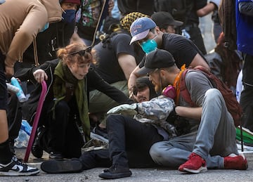 Un manifestante hace una mueca de dolor tras ser alcanzado por un proyectil "menos letal" disparado por agentes de policía durante una protesta contra las redadas federales de inmigración en el centro de Los Ángeles.