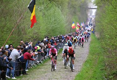Owain Doull, Arnaud Demare y una vista general del pelotón pasando por el sector adoquinado de Trouée d'Arenberg durante la 122.ª edición de la París-Roubaix 2025.