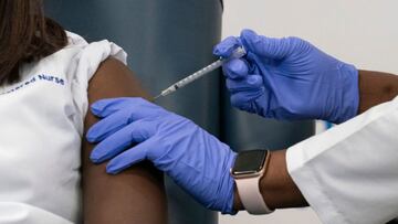 Sandra Lindsay(L), a nurse at Long Island Jewish Medical Center, is inoculated with the Covid-19 vaccine by Dr. Michelle Chester, at Long Island Jewish Medical Center, on December 14, 2020 in the Queens borough of New York. - The rollout of the Pfizer and BioNTech vaccine, the first to be approved by the Food and Drug Administration, ushers in the biggest vaccination effort in US history. More than 299,000 Americans have been killed by the virus, including over 35,000 residents of New York state. (Photo by Mark Lennihan / POOL / AFP) (Photo by MARK LENNIHAN/POOL/AFP via Getty Images)