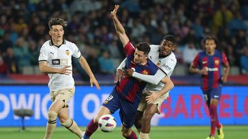 Barcelona's Polish forward #09 Robert Lewandowski (C) fights for the ball with Valencia's Spanish defender #03 Cristhian Mosquera during the Spanish league football match between FC Barcelona and Valencia CF at the Estadi Olimpic Lluis Companys in Barcelona on April 29, 2024. (Photo by LLUIS GENE / AFP)