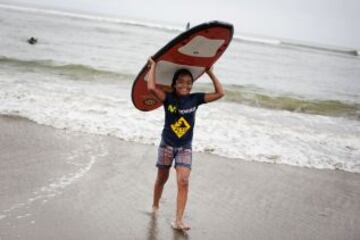 Una muchacha se ríe después de una lección de surf en una playa cerca de Alto Perú barrio de chabolas de Lima