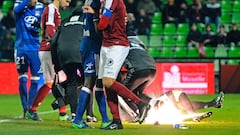 A firecracker explodes beside Lyon and Metz players