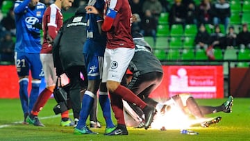 A firecracker explodes beside Lyon and Metz players