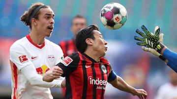Frankfurt's German goalkeeper Kevin Trapp (R) gets the ball ahead of Frankfurt's Japanese midfielder Makoto Hasebe (C) and Leipzig's Danish forward Yussuf Poulsen (R) during the German first division Bundesliga football match RB Leipzig v E