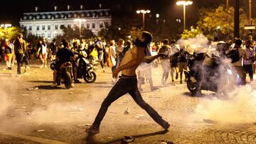 PARIS, FRANCE - JULY 15: French football fans clash with police following celebrations around the Arc de Triomph after France's victory against Croatia in the World Cup Final on July 15, 2018 in Paris, France. France beat Croatia 4-2 in the World Cup
