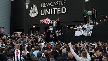 Newcastle United supporters celebrate outside St James' Park after the sale of the football club to a Saudi-led consortium was confirmed in 2021.