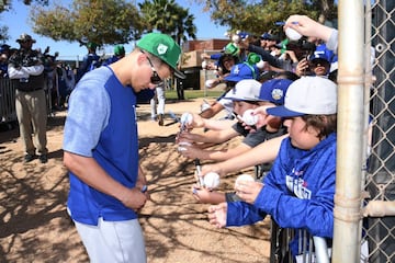 Corey Seager firmando autógrafos en el Spring Training usando la gorra en color verde por St. Patrick's Day.