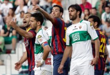 Los jugadores del Barcelona Javier Mascherano (i) y su compañero Sergio Busquets (C) junto a varios jugadores del Elche.