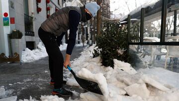 GRAF9244. MADRID, 11/01/2021.- Un hombre retira nieve de la acera este lunes en Madrid. La nieve que ha dejado la borrasca Filomena sigue dificultando e incluso paralizando el tr&aacute;nsito en varios puntos de Espa&ntilde;a y las tareas de limpieza se h