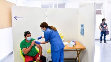 An agricultural worker receives a jab of the J&J/Janssen Covid-19 vaccine at a vaccination centre in Alcarras, near Lleida, on May 22, 2021. - Spain, a key provider of fresh fruit and vegetables to the rest of Europe, is racing to immunise the army of cheap labour that follows the ripening of different crops across the country as the harvest season nears. (Photo by Pau BARRENA / AFP)