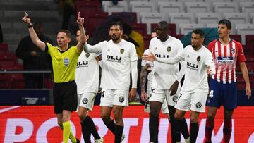 Spanish referee Hernandez Hernandez (L) signs the Video Assistant Referee (VAR) during the Spanish league football match between Club Atletico de Madrid and Valencia CF at the Wanda Metropolitano stadium in Madrid on April 24, 2019. (Photo by GABRIEL BOUY