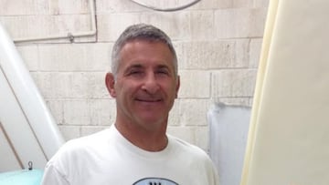 Zen Del Rio junto a varias tablas de surf y sonriendo.