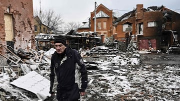 A man walks between houses destroyed during air strikes on the central Ukranian city of Bila Tserkva on March 8, 2022. - Russia stepped up its bombing campaign and missile strikes on Ukraine&#039;s cities, destroying two residential buildings in a town we