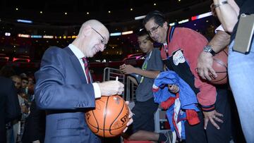 Adam Silver, comisionado de la NBA, firma un balón a un aficionado.