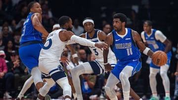 Dallas Mavericks' guard Kyrie Irving #11 is guarded by Minnesota Timberwolves' guard Mike Conley #10