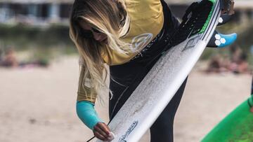 Lucía Martiño echando cera a su tabla de surf durante una prueba de la SuperLiga Siroko.