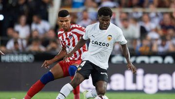 VALENCIA, SPAIN - AUGUST 29: Yunus Musah of Valencia CF competes for the ball with Reinildo Mandava of Atletico de Madrid during the LaLiga Santander match between Valencia CF and Atletico de Madrid at Estadio Mestalla on August 29, 2022 in Valencia, Spain. (Photo by Francisco Macia/Quality Sport Images/Getty Images)
