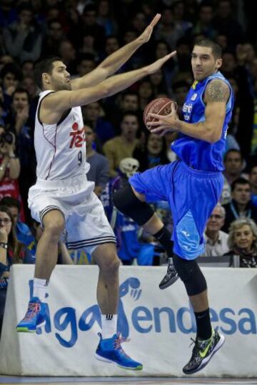 El alero del Estudiantes Nacho Martín con el balón ante el pívot del Real Madrid Felipe Reyes.