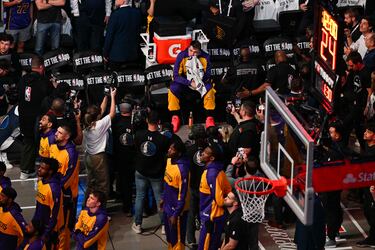 Luka Doncic se seca las lágrimas mientras observa el vídeo homenaje que le hicieron los Mavericks antes del partido entre Lakers y Mavericks.
