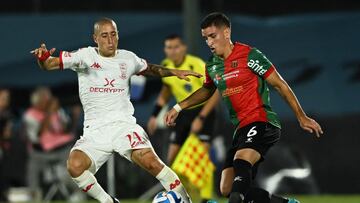 Huracan's midfielder Federico Fattori (L) fights for the ball with Boston River's defender Emanuel Beltran during the Copa Libertadores stage two first leg football match between Uruguay's Boston River and Argentina's Huracan, at the Centenario stadium in Montevideo, on February 22, 2023. (Photo by Pablo PORCIUNCULA / AFP)