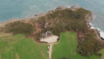 La playa de Gulpiyuri (Asturias) vista desde el aire, con el mar al fondo y los campos en primer plano. 