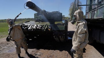 German servicemen in protective suits show decontamination of Leopard 2 tank during media day of NATO military exercise in Rukla, Lithuania May 10, 2022. REUTERS/Janis Laizans