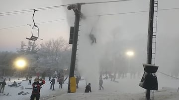 Un esquiador que viaja en el telesilla de la estación de esquí de Beech Mountain (Carolina del Norte, Estados Unidos) queda atrapado bajo el chorro de agua de una tubería rebentada mientras rescate y otros esquiadores se lo miran. El 7 de enero del 2022.