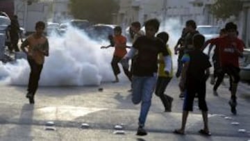 Unos ni&ntilde;os escapan del gas lacrim&oacute;geno lanzado por la polic&iacute;a durante una marcha para protestar por la celebraci&oacute;n del Gran Premio de F&oacute;rmula 1.