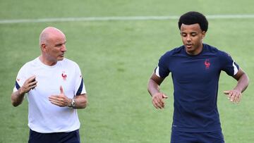 France's assistant coach Guy Stephan (L) speaks with France's defender Jules Kounde during a MD-1 training session at the Hidegkuti Stadium in Budapest on June 22, 2021, on the eve of their UEFA EURO 2020 Group F football match against Portugal.
