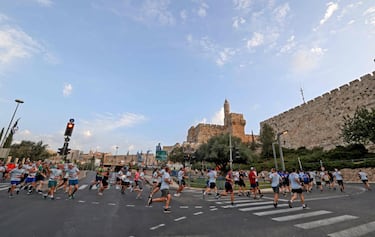 Un grupo de corredores pasa por las proximidades de la Puerta de Jaffa, en la Ciudad Vieja, durante el Maratón de Jerusalén, que ayer celebró su décima edición tras un año de pausa por la pandemia. La prueba congregó a unos 17.000 participantes, que recorrieron lugares tan emblemáticos y llenos de historia como el de la imagen. 