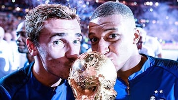 Antoine Griezmann y Kylian Mbapp&eacute; besando la Copa del Mundial 2018 tras ganarla con la selecci&oacute;n de Francia.