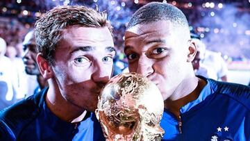 Antoine Griezmann y Kylian Mbappé besando la Copa del Mundial 2018 tras ganarla con la selección de Francia.
