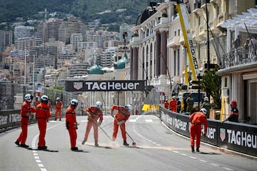 Los comisarios de carrera limpian la pista después del accidente de Checo Pérez.